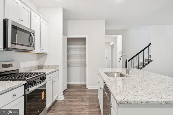 a kitchen with stainless steel appliances granite countertop a sink and a stove