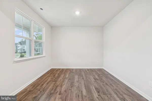 a view of a room with wooden floor and windows