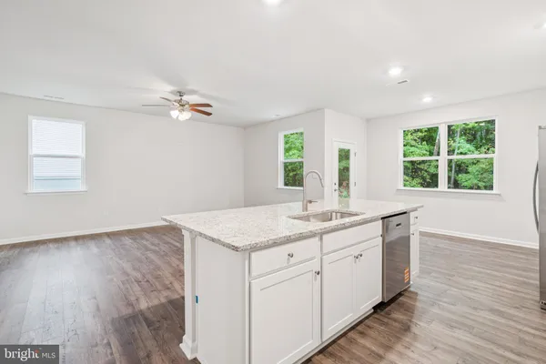 a kitchen with a sink cabinets and wooden floor