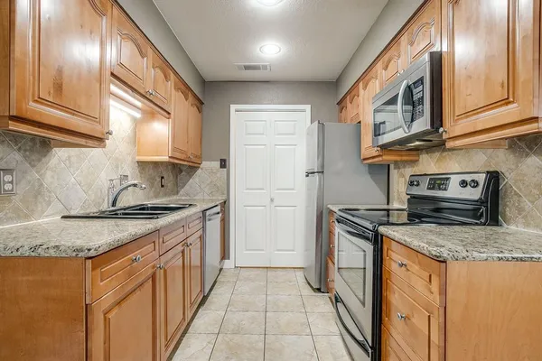 a kitchen with stainless steel appliances granite countertop a stove and a sink