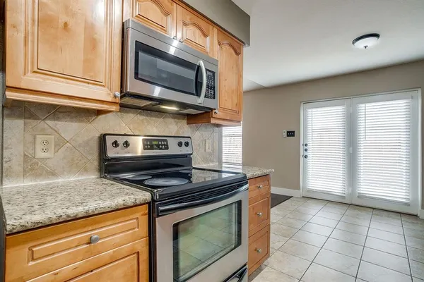 a kitchen with granite countertop cabinets stainless steel appliances and a window