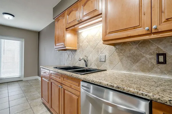 a kitchen with granite countertop a sink and a stove