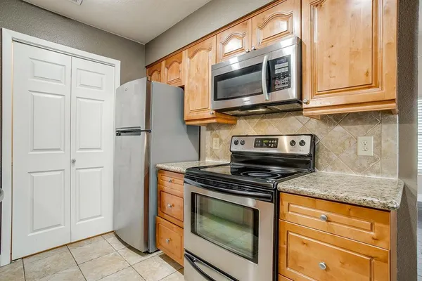 a kitchen with stainless steel appliances granite countertop a stove microwave and refrigerator
