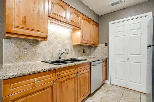 a kitchen with stainless steel appliances granite countertop a sink and cabinets