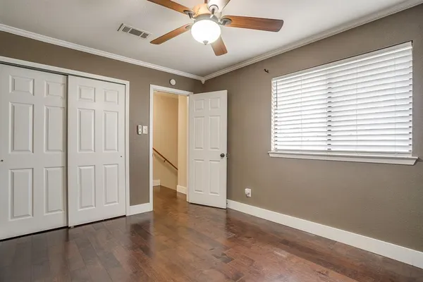 a view of an empty room with a window and wooden floor