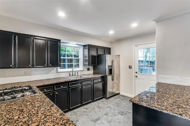 a kitchen with stainless steel appliances granite countertop a sink stove and refrigerator