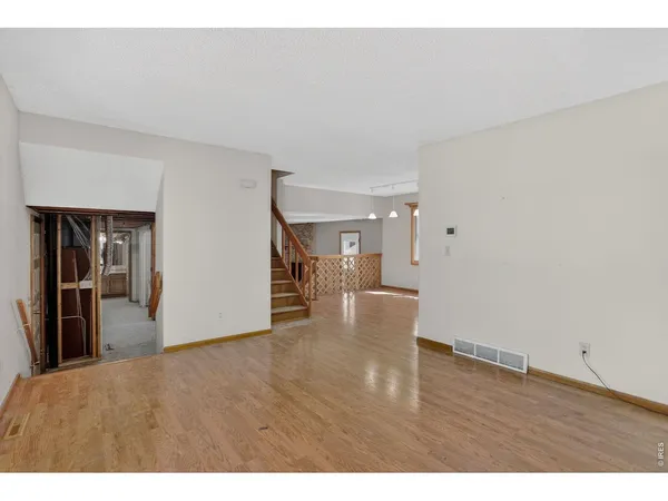 a view of empty room with wooden floor