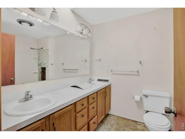 a bathroom with a sink double vanity and a toilet