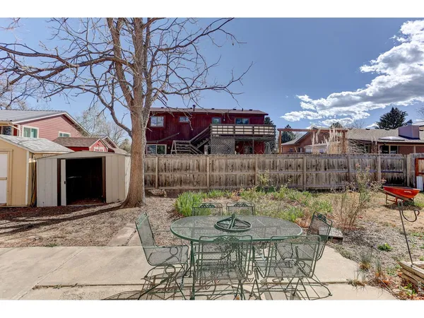 a view of a chairs and table in backyard