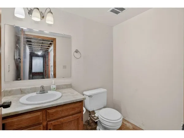 a bathroom with a sink toilet a mirror and vanity