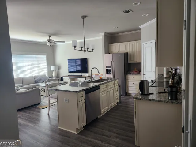 a kitchen with stainless steel appliances granite countertop a sink stove and refrigerator