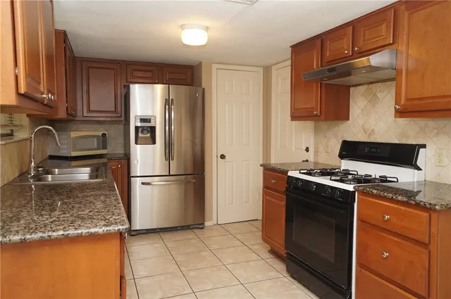 a kitchen with a stove top oven a sink and a refrigerator