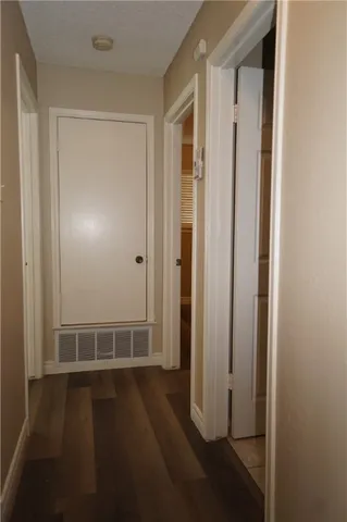 an empty room with wooden floor door and windows