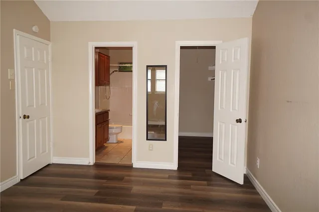 a view of a hallway with wooden floor and entryway