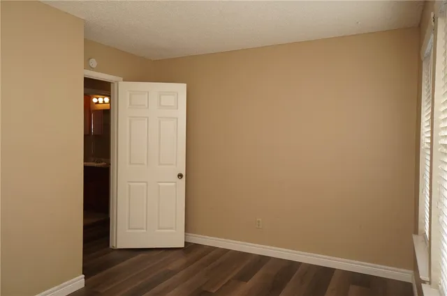 an empty room with wooden floor and closet
