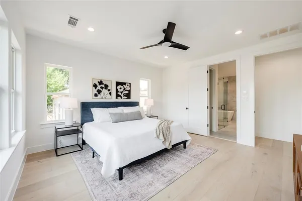 a spacious bedroom with a bed and a large window