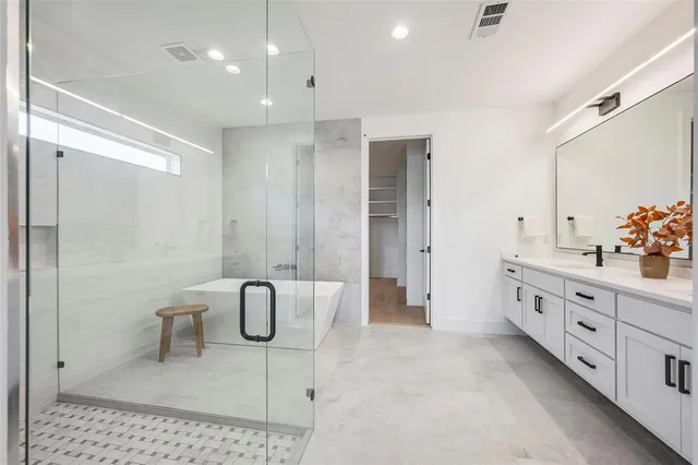 a bathroom with a granite countertop bathtub sink and mirror