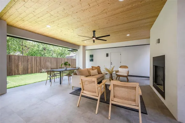 a view of a patio with table and chairs with wooden floor and fence