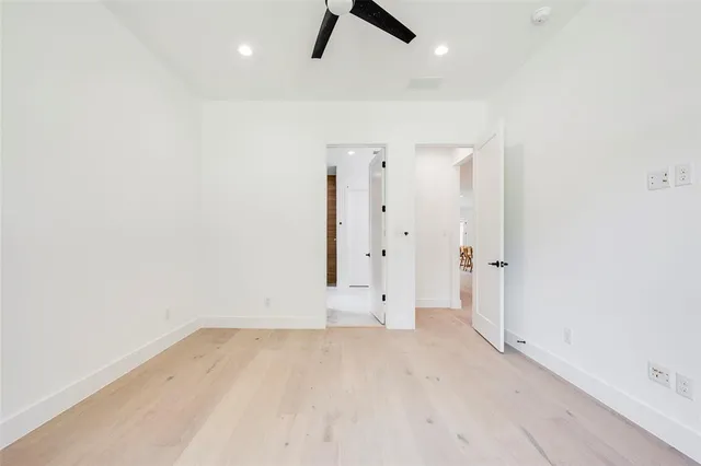 an empty room with ceiling fan and window