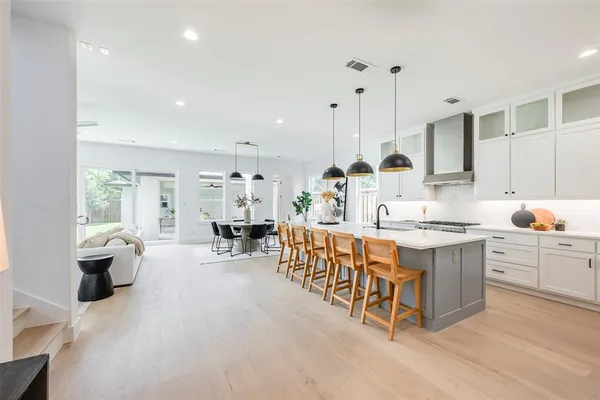 a large kitchen with kitchen island a large window a sink and stainless steel appliances