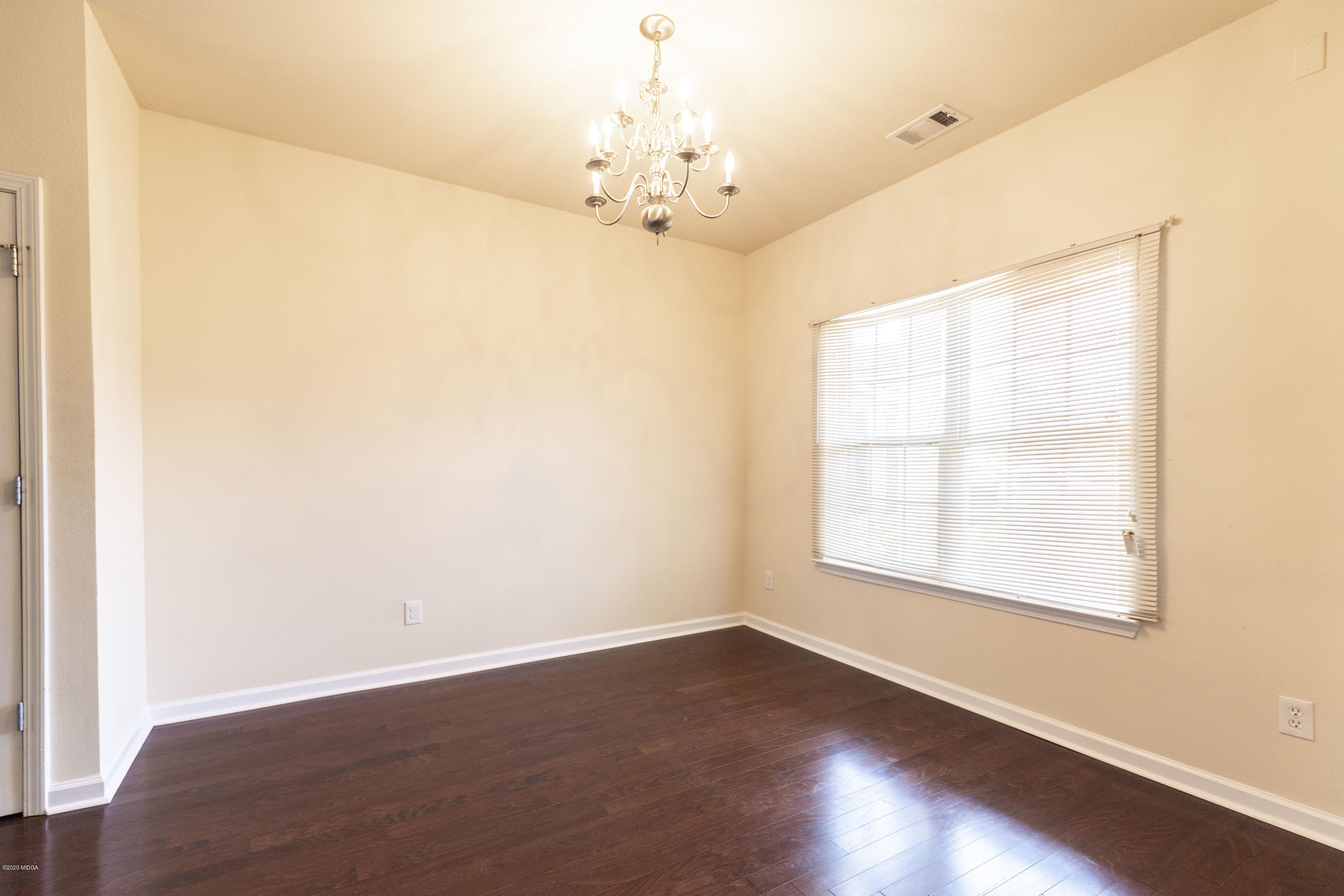 415 Bob White Road Macon, GA 31216 - Photo 8 of 43 an empty room with wooden floor chandelier and windows