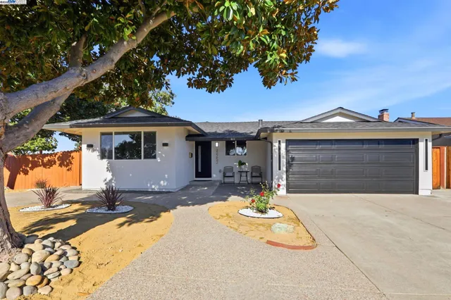 a front view of a house with a yard outdoor seating and garage