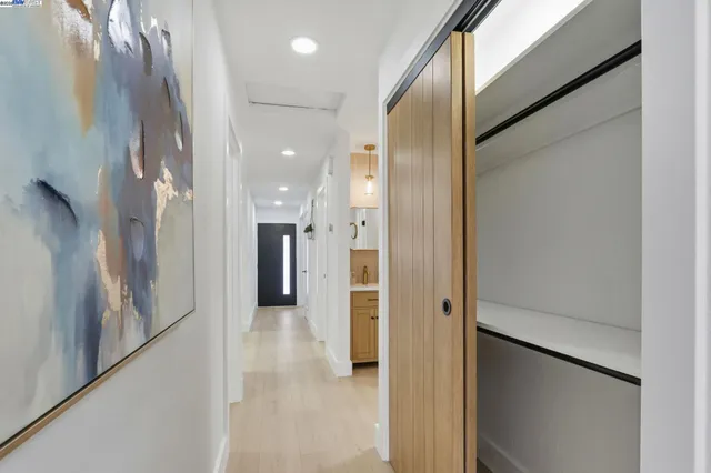 a view of a hallway with wooden shelves