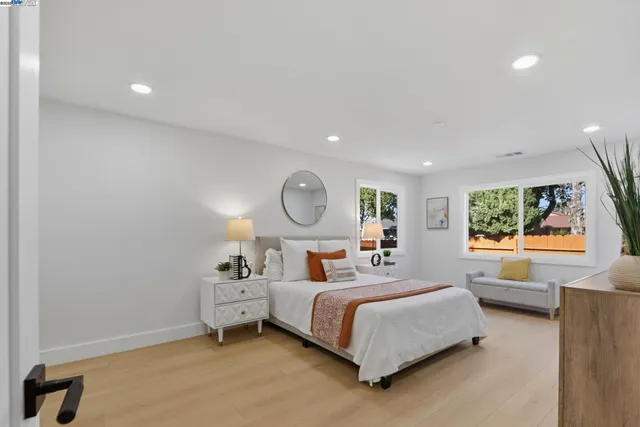 a bedroom with a bed mirror and window