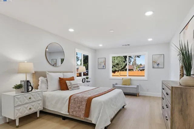 a spacious bedroom with a bed and a dresser