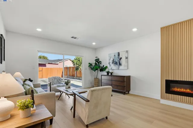 a living room with furniture a window and wooden floor