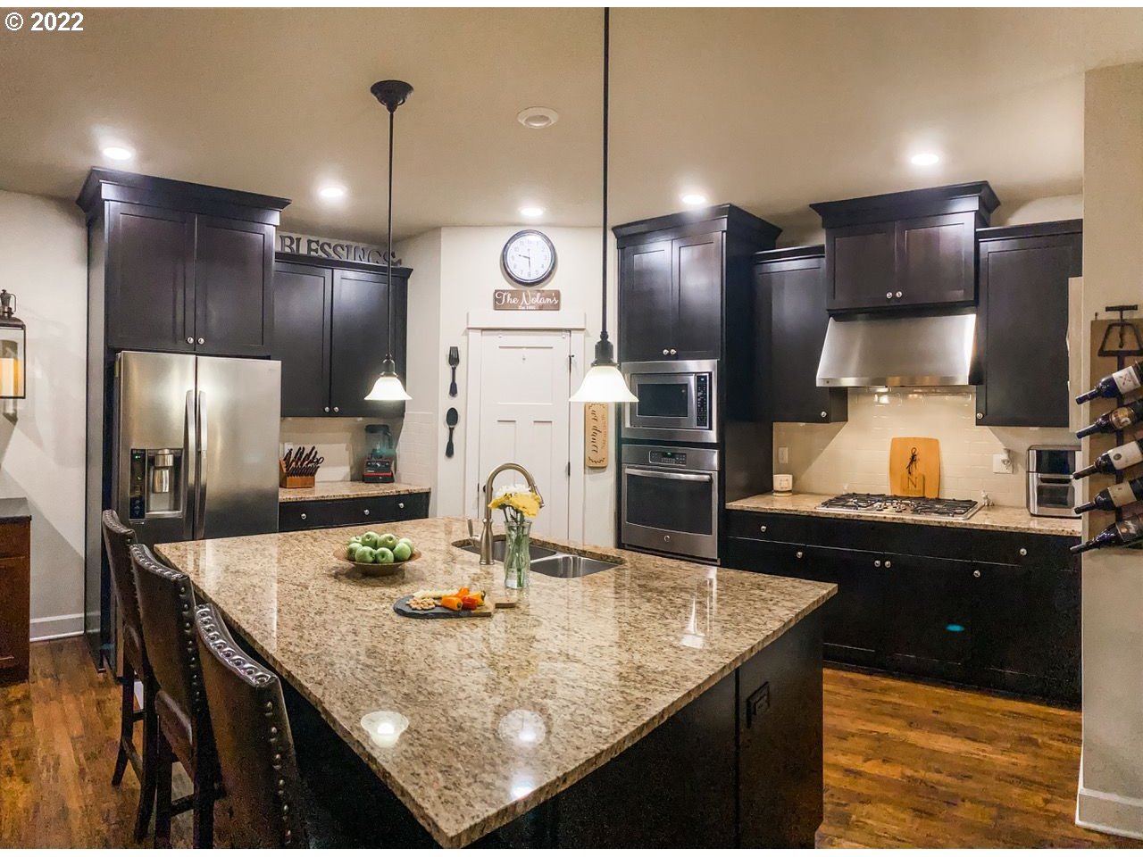 6873 Southwest Locust Street Tigard, OR 97223 - Photo 2 of 6 a kitchen with stainless steel appliances kitchen island granite countertop a refrigerator a sink a stove and chairs