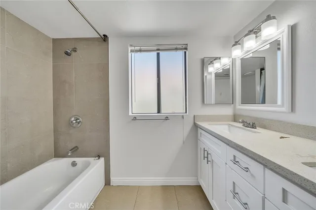 a bathroom with a tub sink and mirror