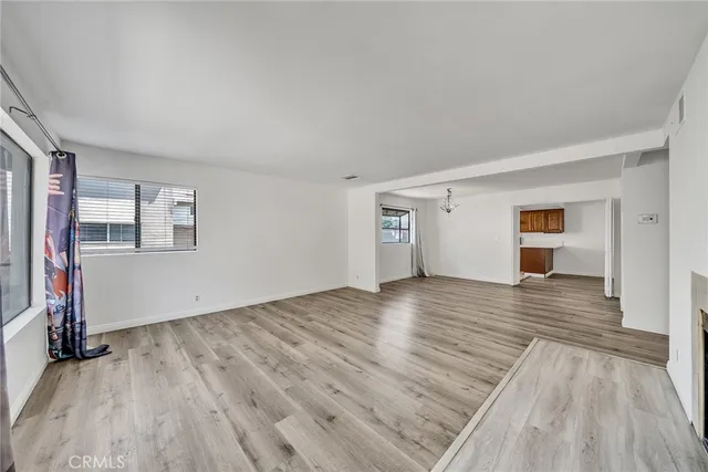 a view of empty room with wooden floor and window