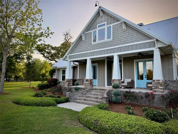 a front view of a house with a yard and outdoor seating