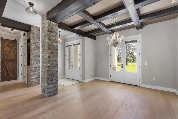 a view of an empty room with closet and wooden floor