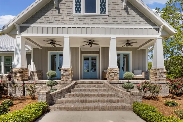 a backyard of a house with wooden fence and large trees