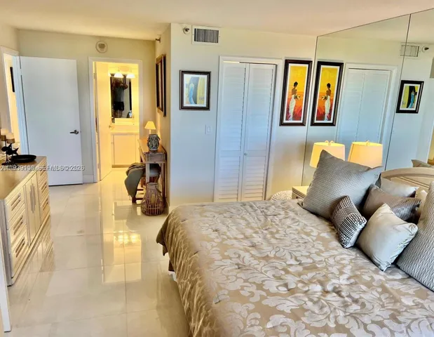 a kitchen with stainless steel appliances kitchen island granite countertop a refrigerator a stove a sink a dining table and chairs with wooden floor