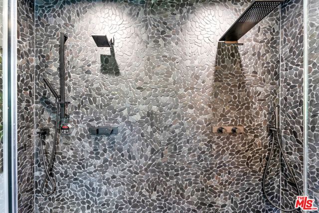 a large kitchen with stainless steel appliances a large counter top a stove a refrigerator a sink a microwave and a refrigerator