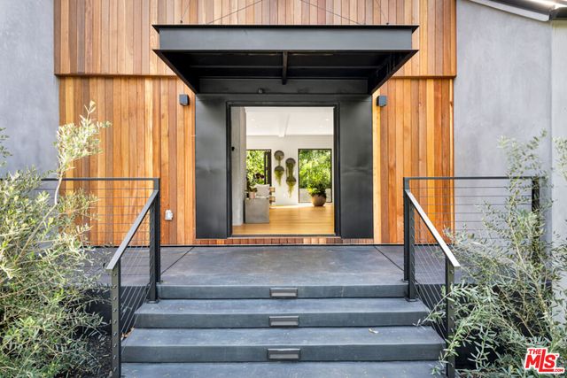 a view of a patio with a table chairs and a floor to ceiling window