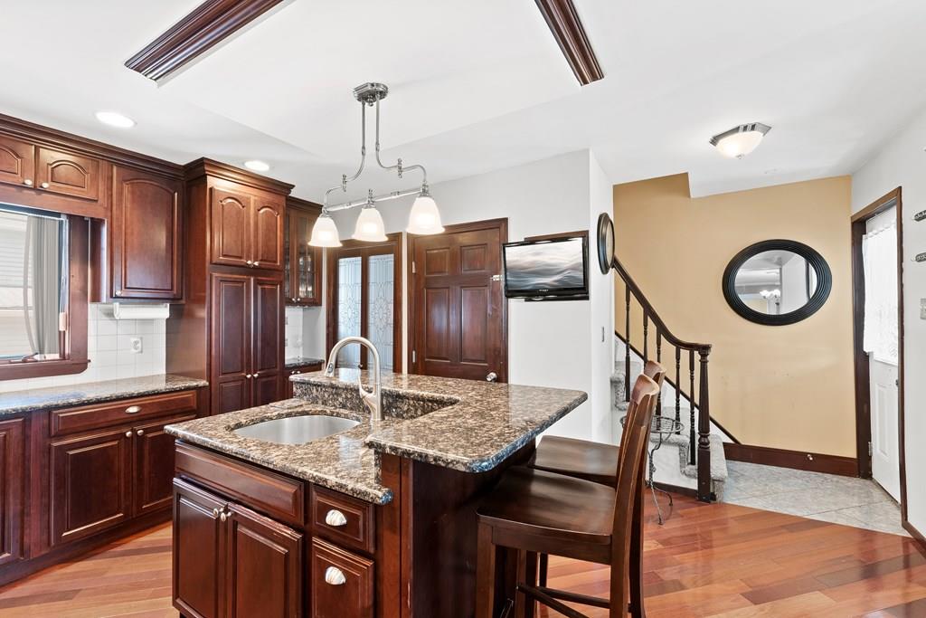 143 18th Street Lowell, MA 01850 - Photo 19 of 35 a kitchen with granite countertop cabinets and refrigerator