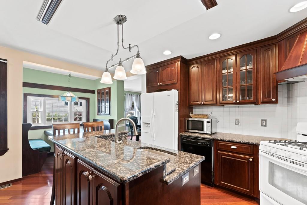 143 18th Street Lowell, MA 01850 - Photo 20 of 35 a kitchen with stainless steel appliances granite countertop a sink stove and refrigerator