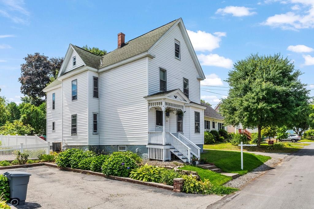 143 18th Street Lowell, MA 01850 - Photo 5 of 35 a front view of a house with a garden