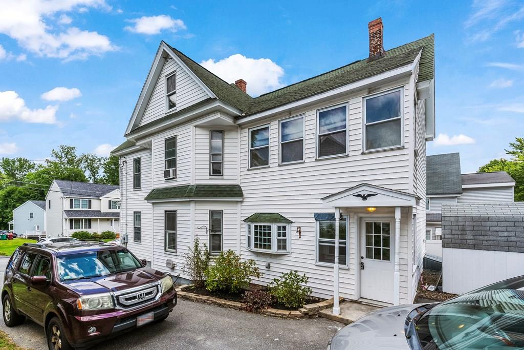 143 18th Street Lowell, MA 01850 - Photo 9 of 35 a car parked in front of a white house