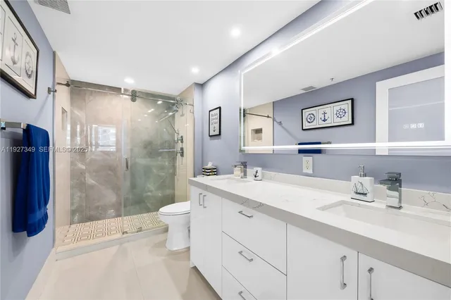 a bathroom with a shower sink vanity mirror and toilet
