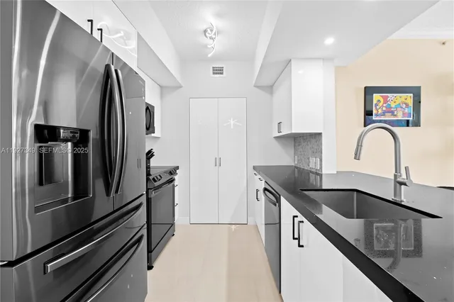 a kitchen with stainless steel appliances granite countertop a sink stove and refrigerator