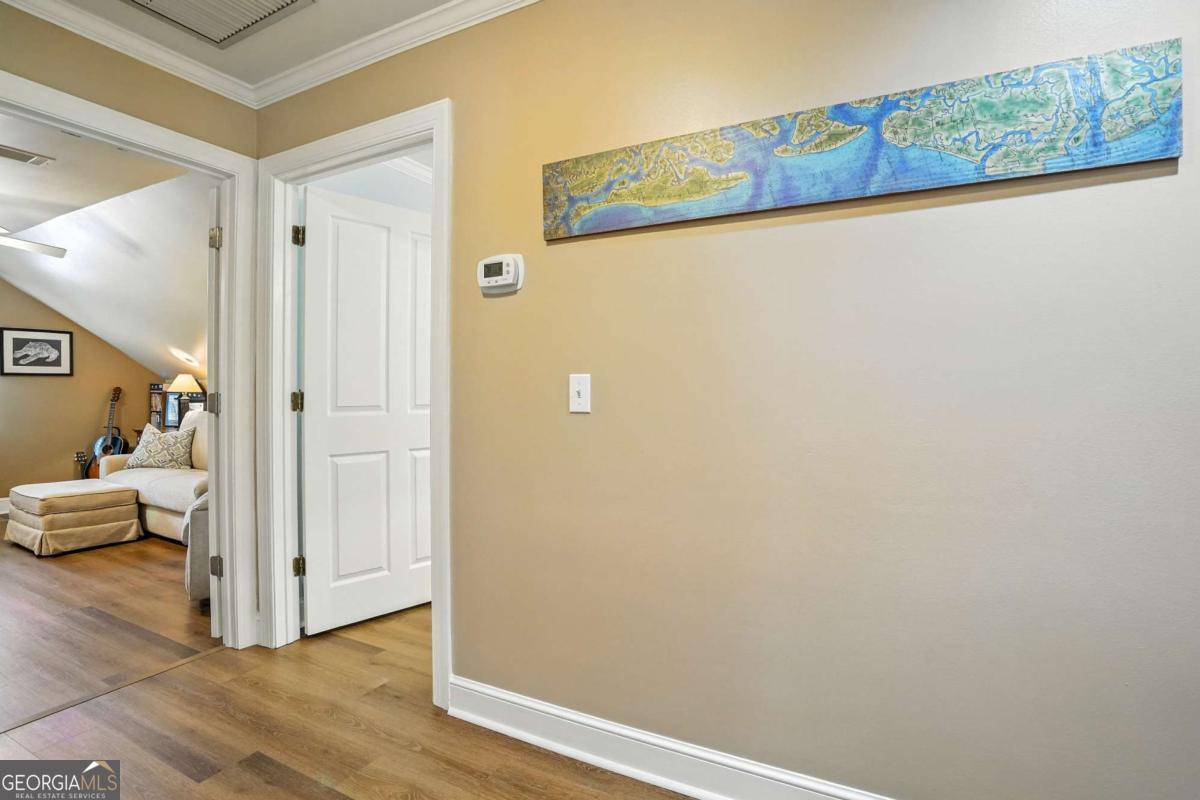 202 Vassar Point Drive St. Simons, GA 31522 - Photo 24 of 62 a view of a hallway with wooden floor and bedroom view