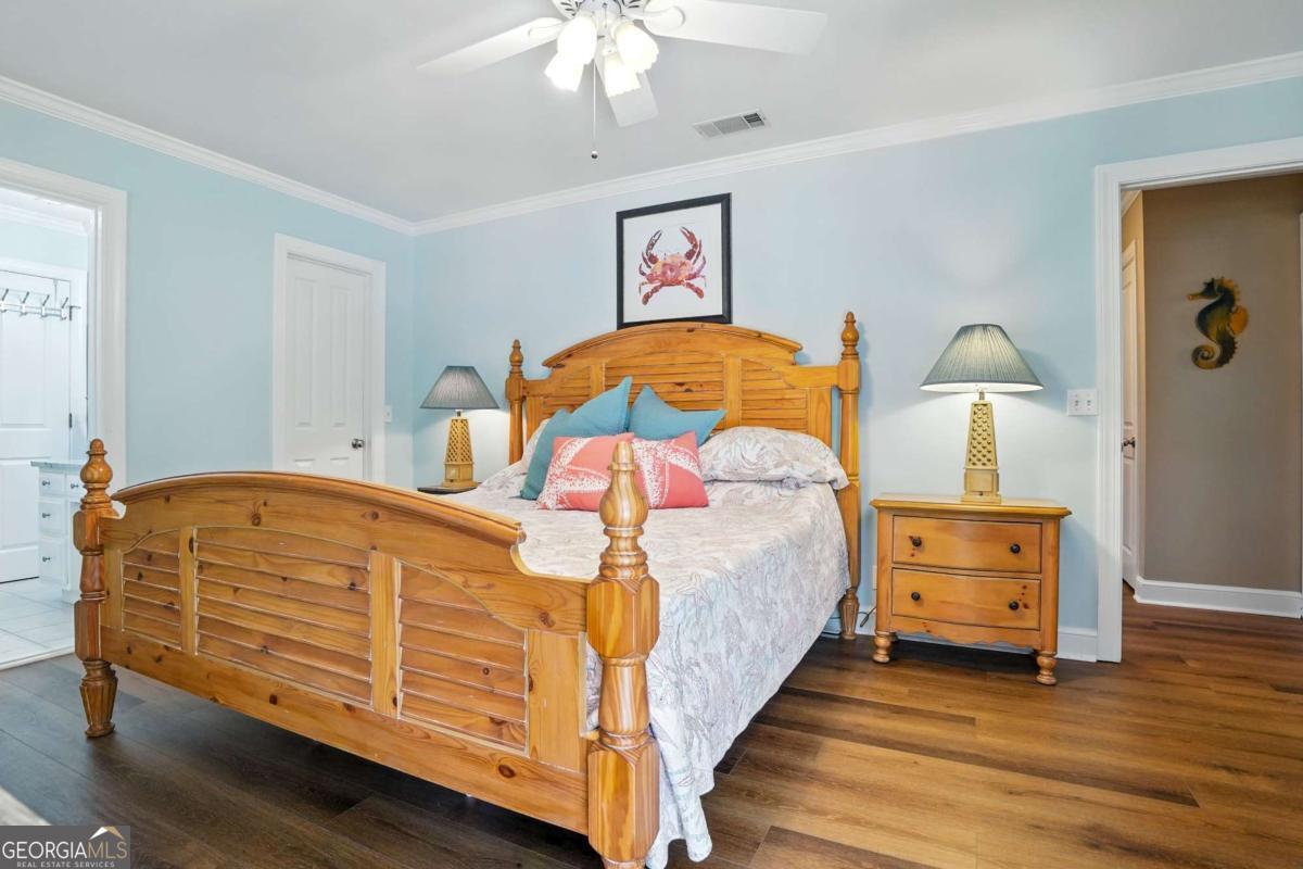 202 Vassar Point Drive St. Simons, GA 31522 - Photo 27 of 62 a bedroom with a bed and wooden floor
