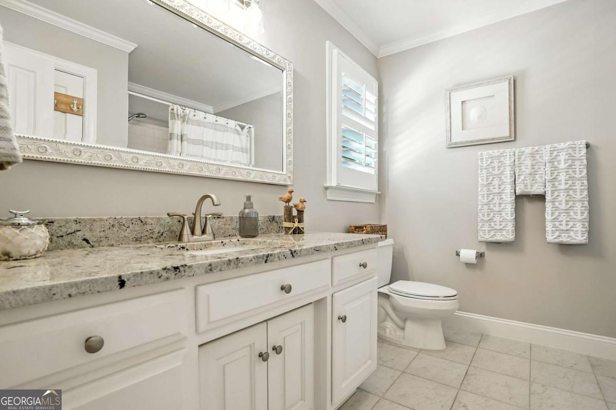 202 Vassar Point Drive St. Simons, GA 31522 - Photo 36 of 62 a bathroom with a granite countertop toilet sink and mirror