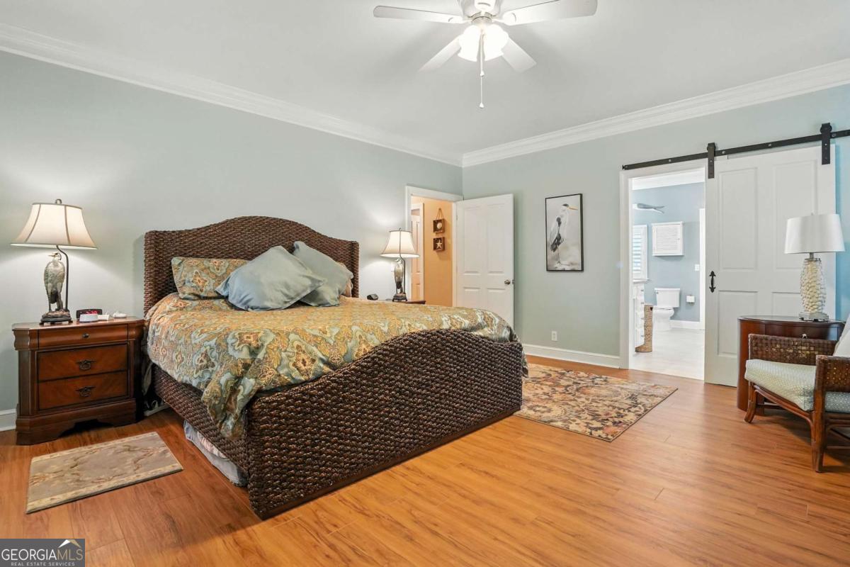 202 Vassar Point Drive St. Simons, GA 31522 - Photo 42 of 62 a bedroom with a bed and a chandelier