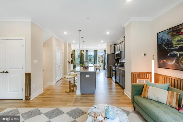 a living room with furniture and a dining table with kitchen view